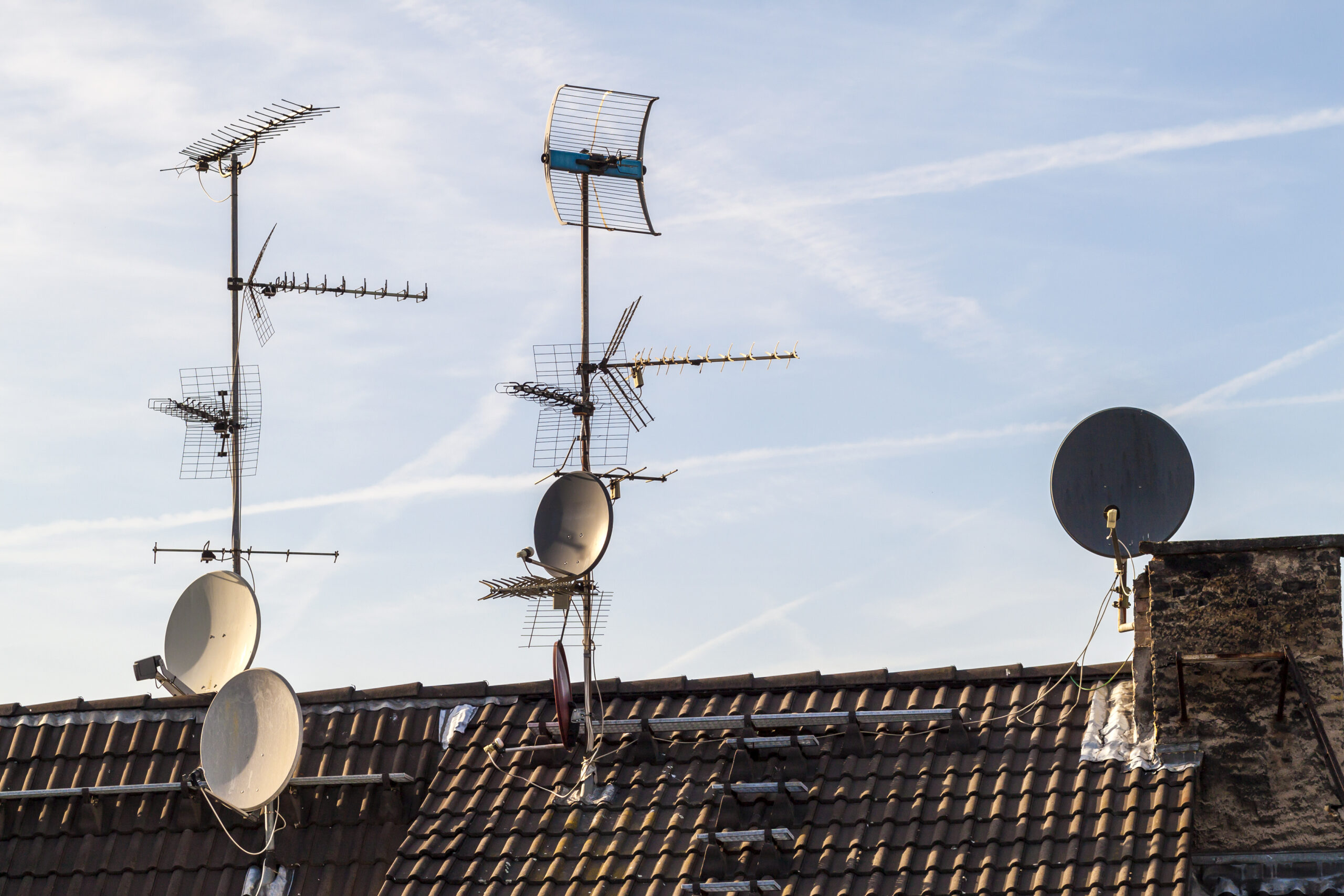 Old building roof with many different type receiver telecommunication antennas